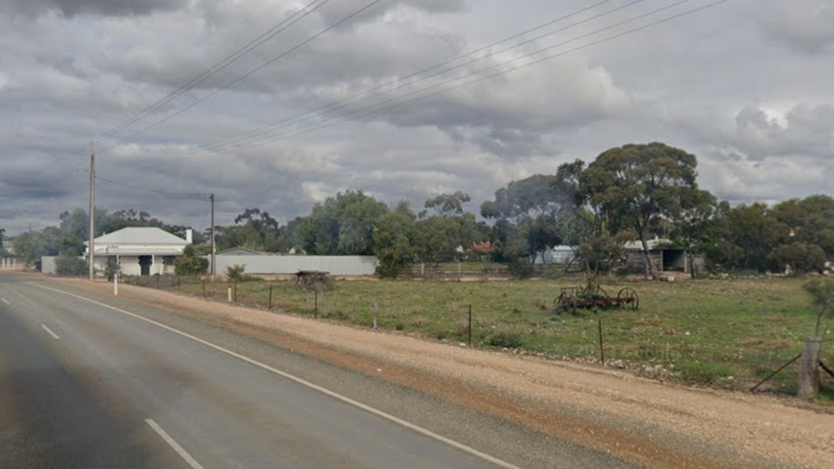 A street view image of a street in Moonta. The roads are dusty and the fields are green.