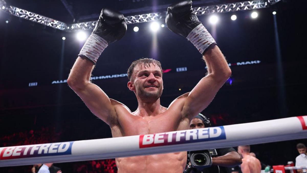 Josh Padley smiling at the crowd with his hands raised