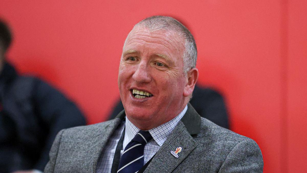 Ralph Rimmer, smiling, dressed in jacket and tie