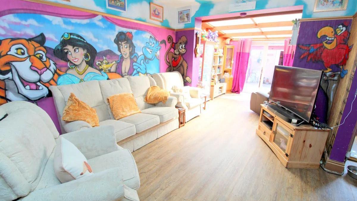 A living room with characters from Disney's Aladdin painted on its walls.