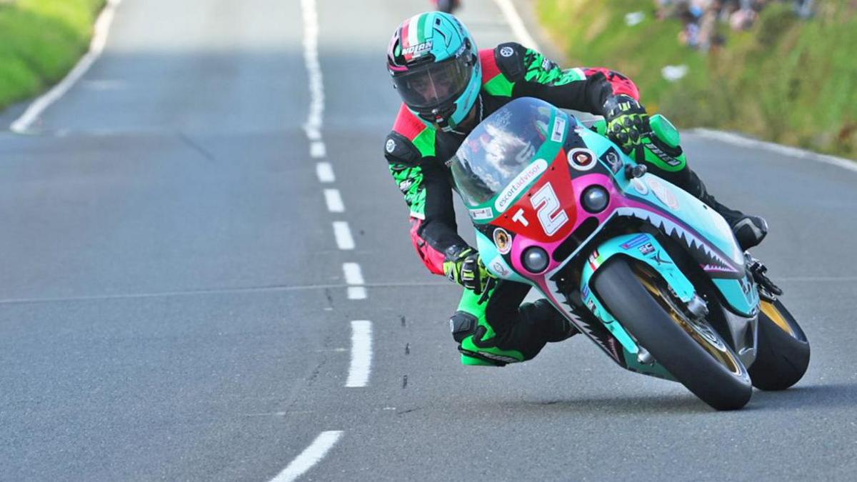 Andrea Majolo on a blue and pink bike with the number two on a red plate. He's wearing green and pink leathers.