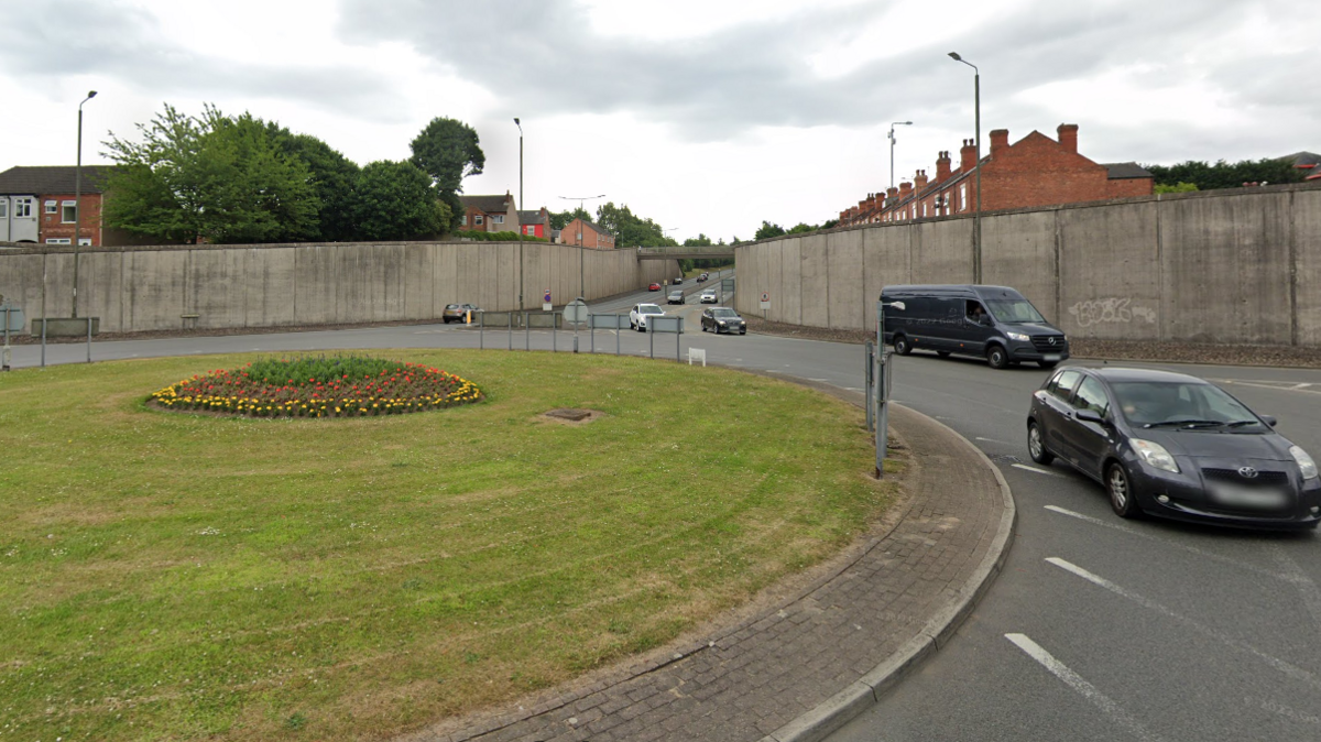 Roundabout leading onto Chalons Way with cars and vans passing through it