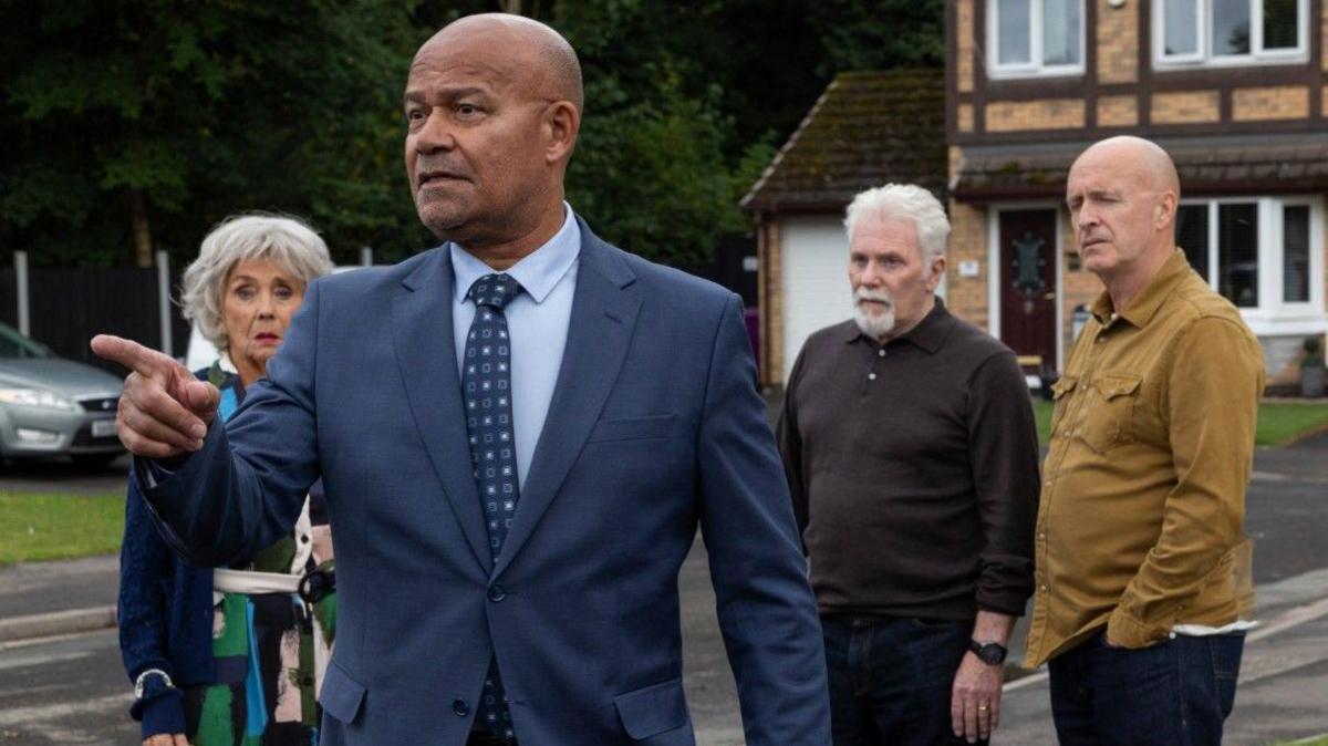 Louis Emerick, Sue Johnston, Paul Usher and John McArdle are captured in this candid shot during filming on Brookside Close.