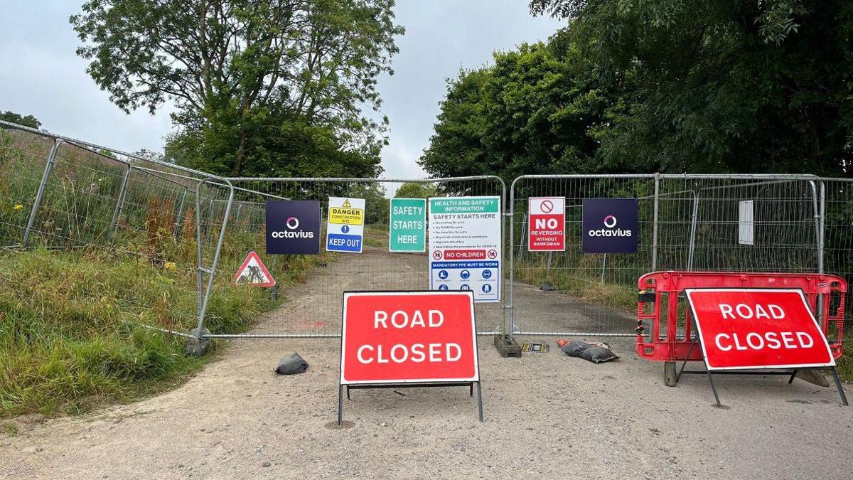 Two road closure signs in front of a construction site