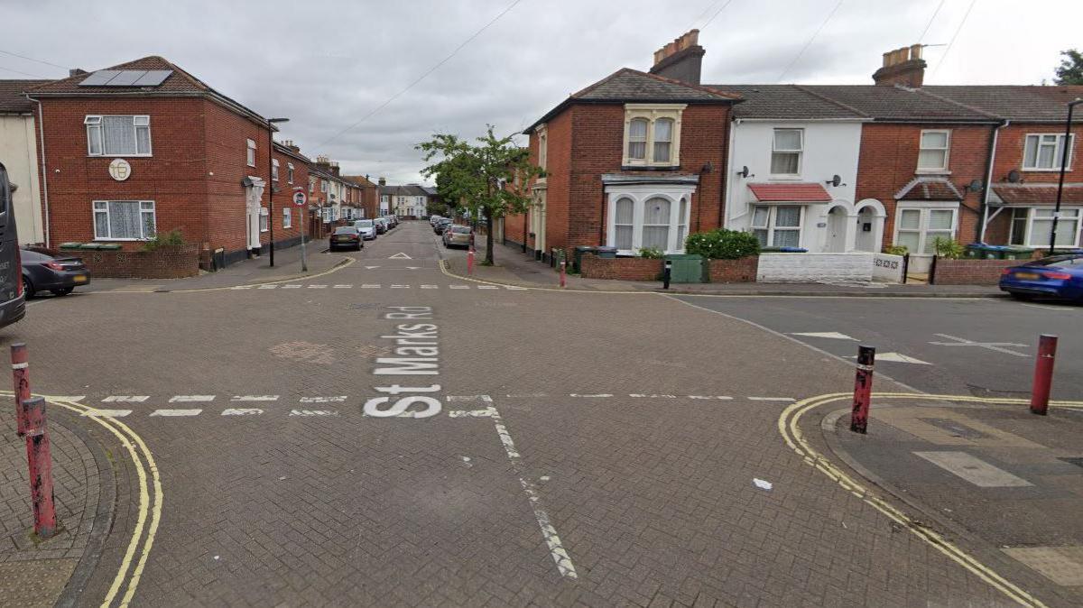 A Google Street View of a crossroads in the middle of a residential area of terraced houses.