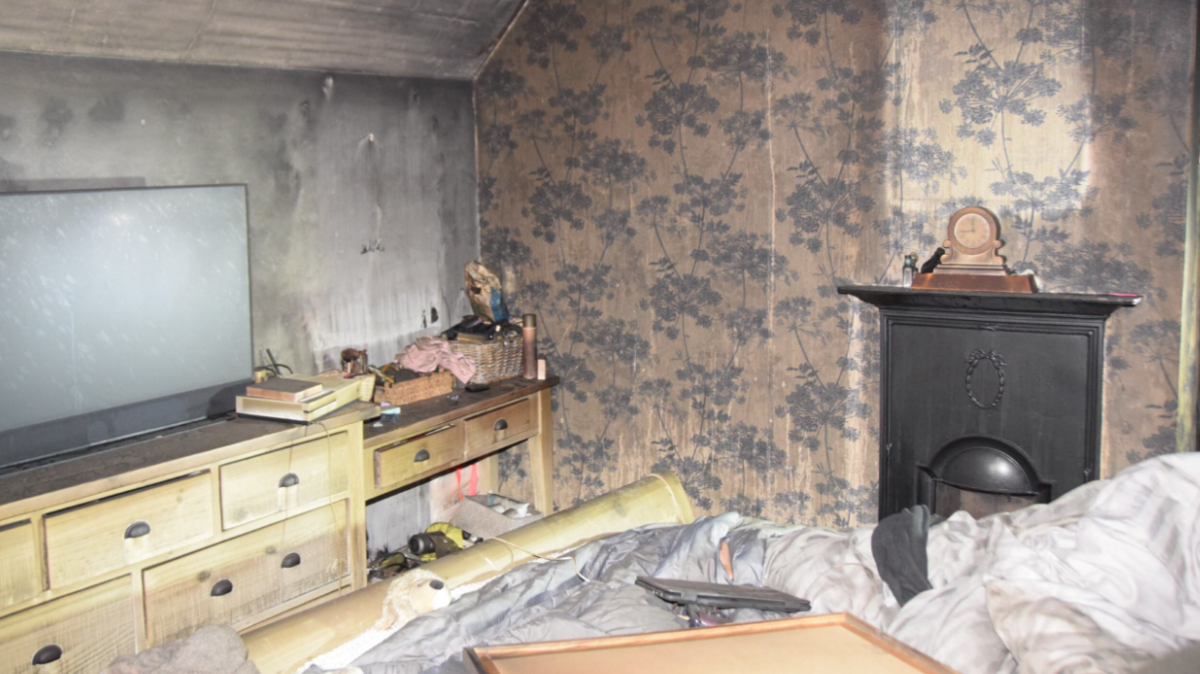 The Chilworth home of Emma Wills after a modified e-bike caused a fire which destroyed much of the property. The bedroom in the image has a black wall and destroyed wallpaper.