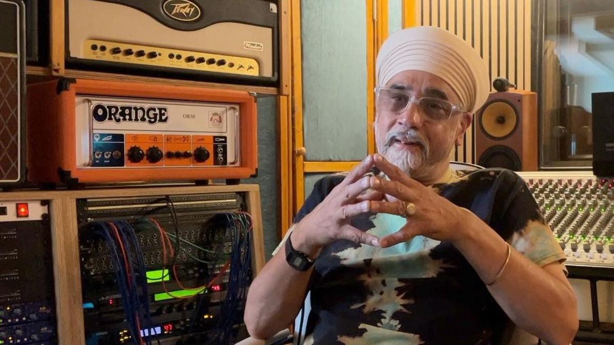 Inder Goldfinger sat in the studio wearing a green and black printed top.