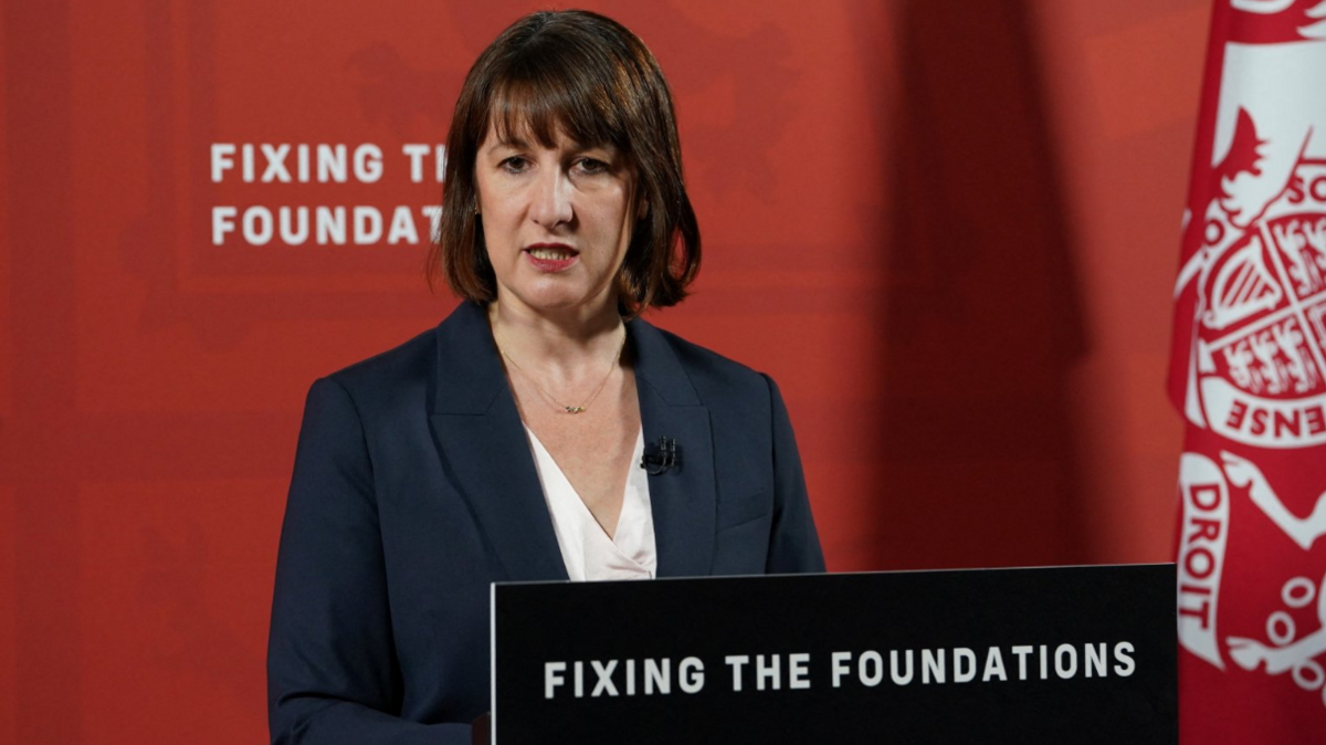 Chancellor Rachel Reeves giving a press conference behind a lectern which reads "fixing the foundations"