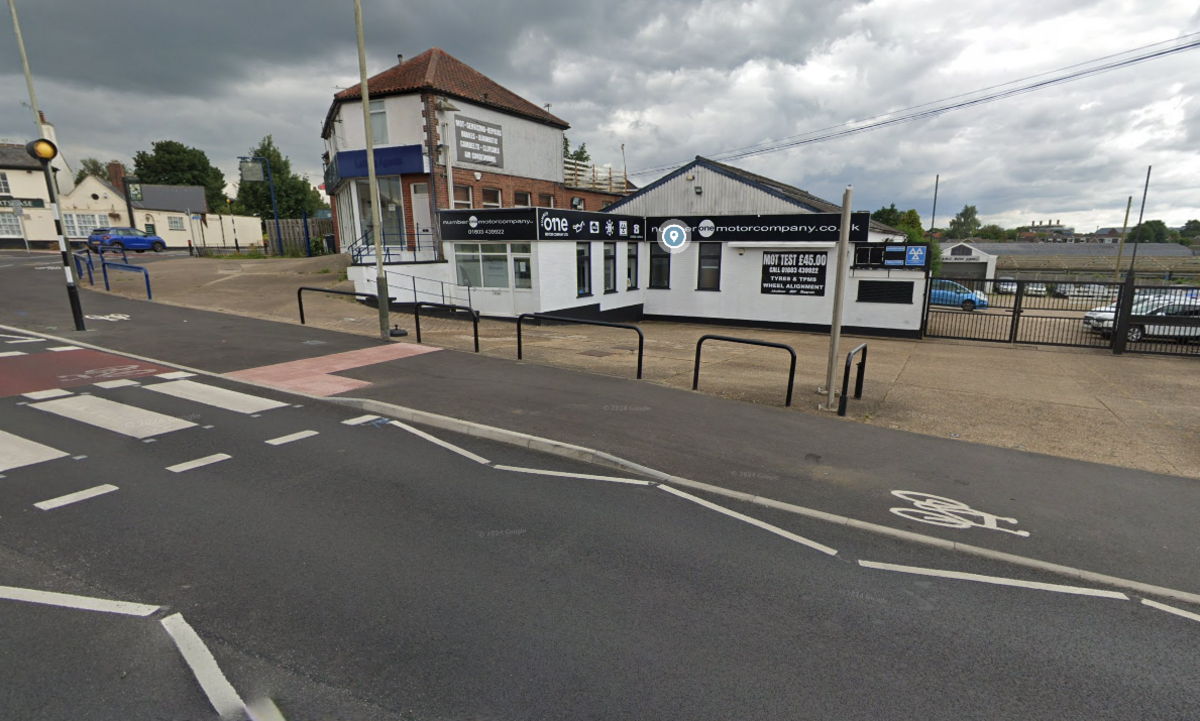 Number One Motor Company showing empty forecourt and zebra crossing on road outside 