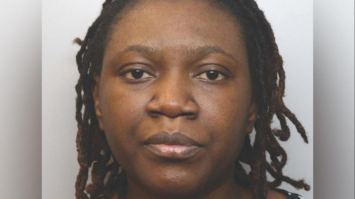 A police mugshot shows a woman looking directly at the camera