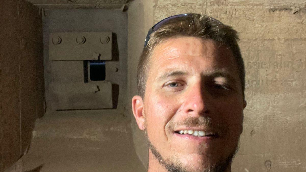 Shaun Tullier smiles at the camera while stood in the German World War Two bunker under his house in Guernsey.