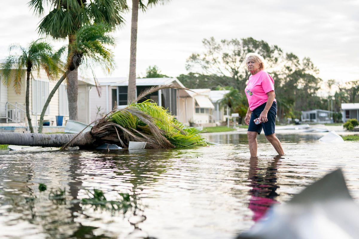 A woman in a pink top walks along a flooded street in the aftermath of Hurricane Milton on October 10, 2024 in Osprey, Florida.