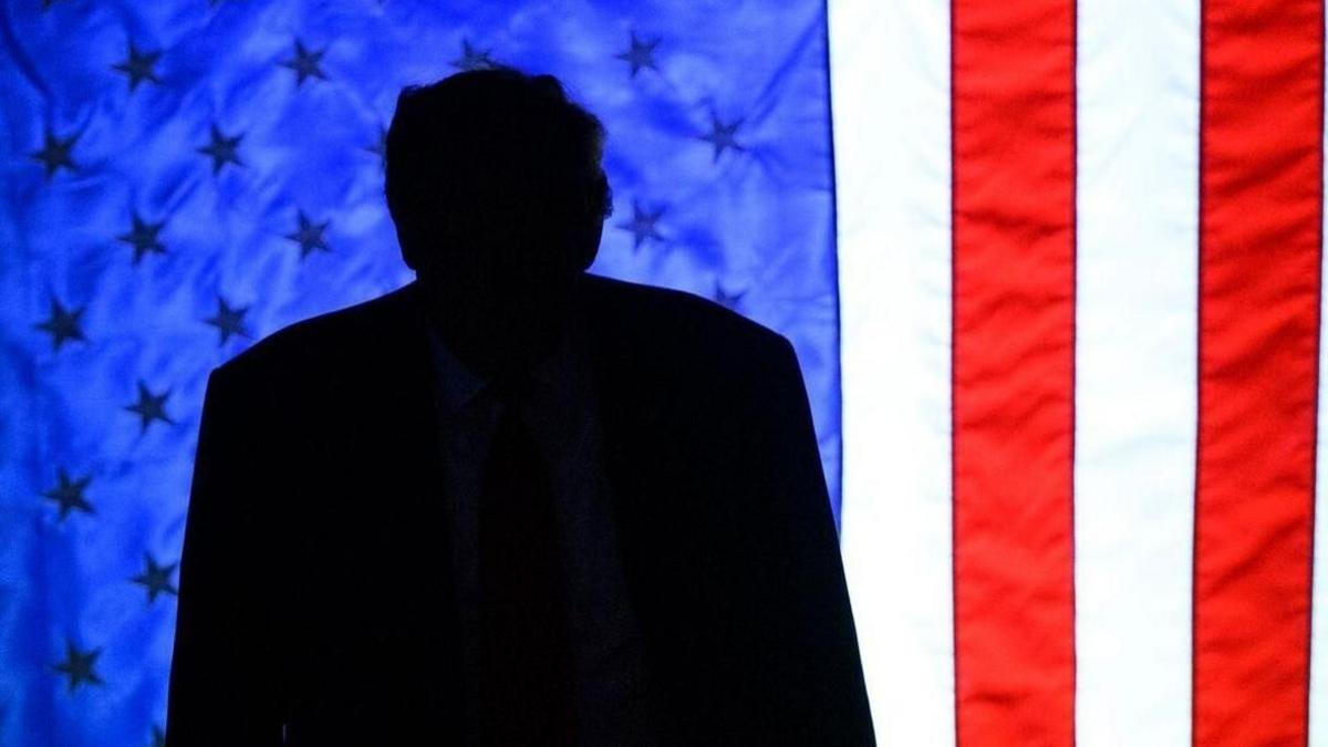 A silhouette of Donald Trump against the American flag