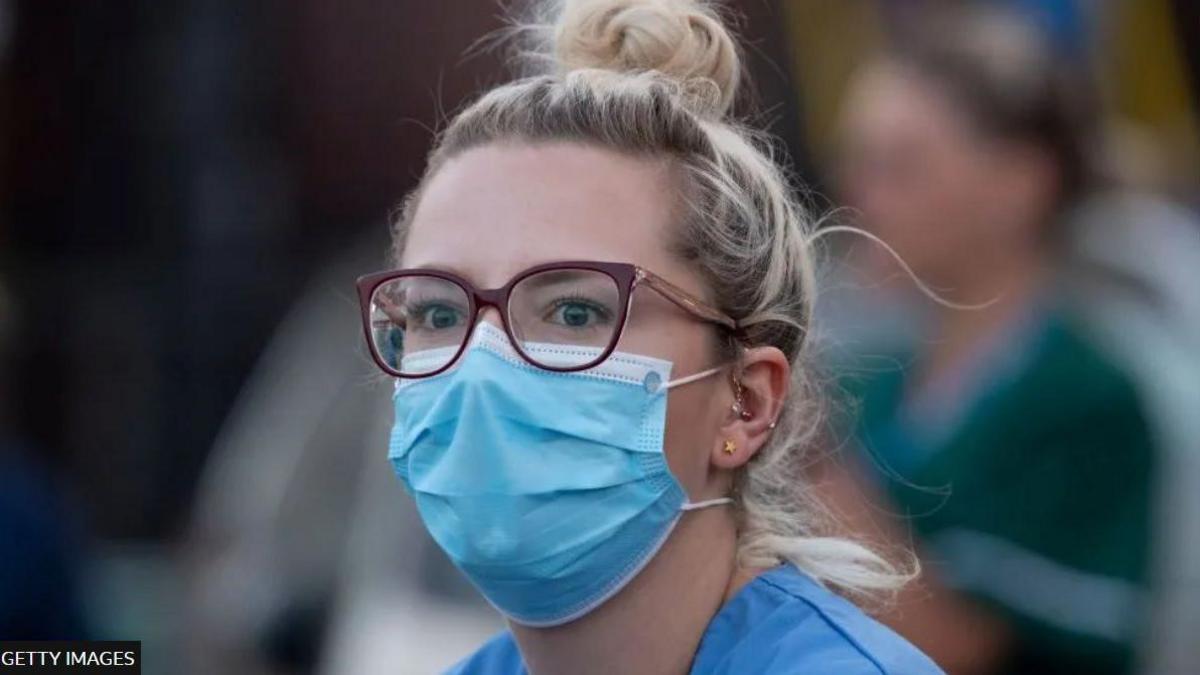 Nurse wearing face mask with frightened expression in eyes, during the pandemic