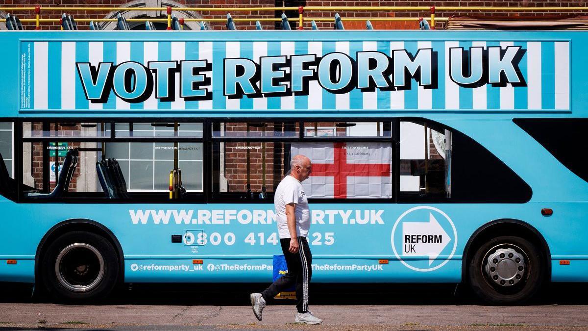 A person walks past a Reform UK campaign bus outside Clacton station in Clacton-on-Sea, Essex, Britain, 04 August 2026. Reform UK leader Nigel Farage will contest the Clacton by-election on 13 August in an effort to regain his seat after announcing his resignation as an MP on 07 July 2026 following a row over his financial affairs. Major UK political parties are not contesting the election, while satirical candidate Count Binface is polling second with support from around 20 percent of Clacton voters, according to a recent Survation poll. Clacton ahead of parliamentary by-election, Essex, United Kingdom - 04 Aug 2026