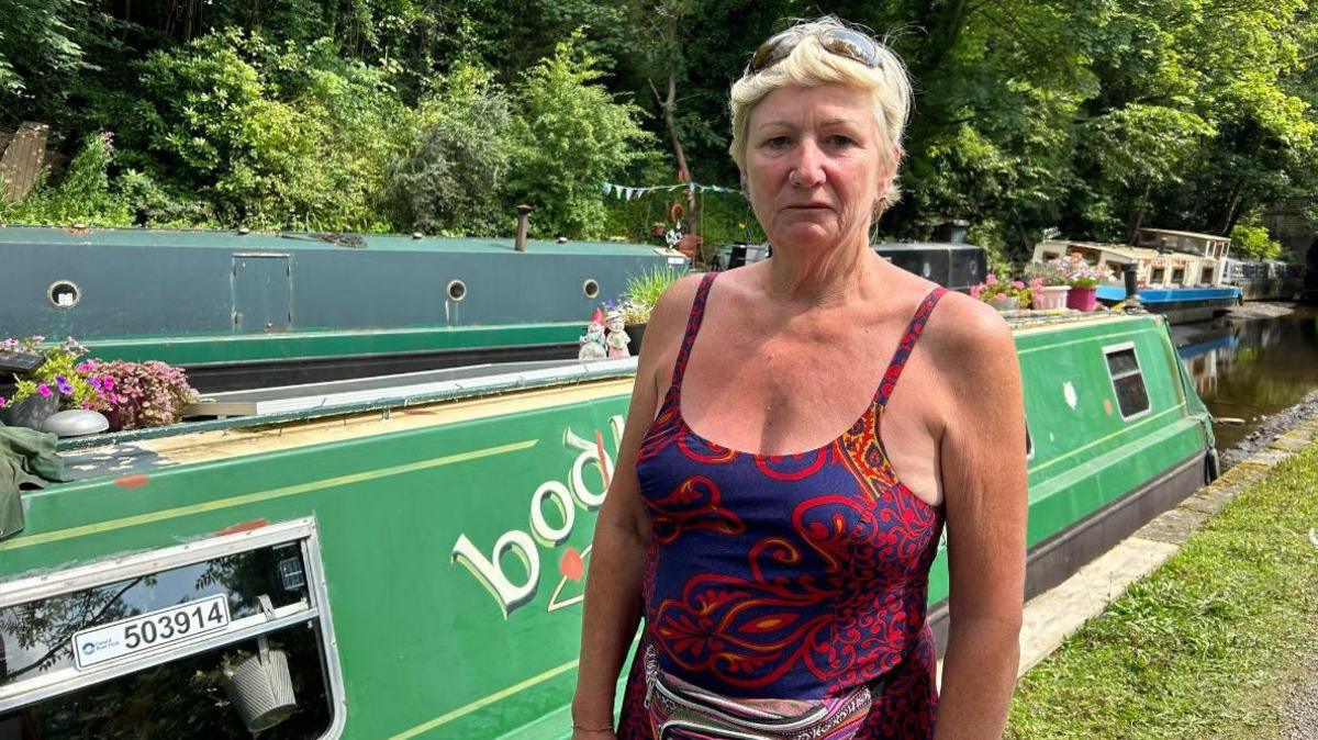 Wendy Wells standing in front of the canal boat she owns 