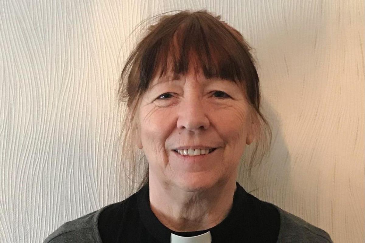 Head-and-shoulders image of Annie Gray. She is smiling as she looks directly into the camera. She has dark hair with a fringe. She is wearing a cleric's dog collar.