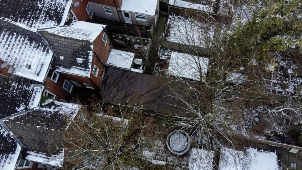 An aerial view of gardens, with the garden in which Abiyah was found covered over by black tarpaulin