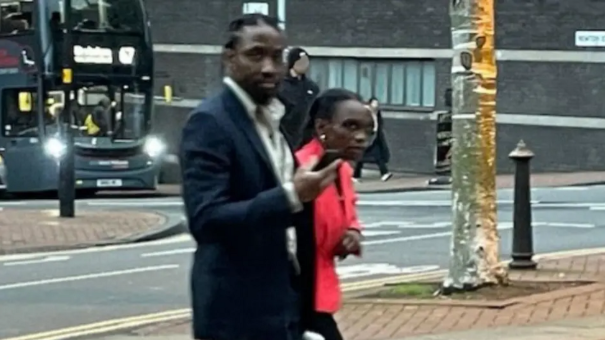 Tai Yasharahyalah, in a black suit, and Naiyahmi Yasharahyalah, in a red jacket, walking to court