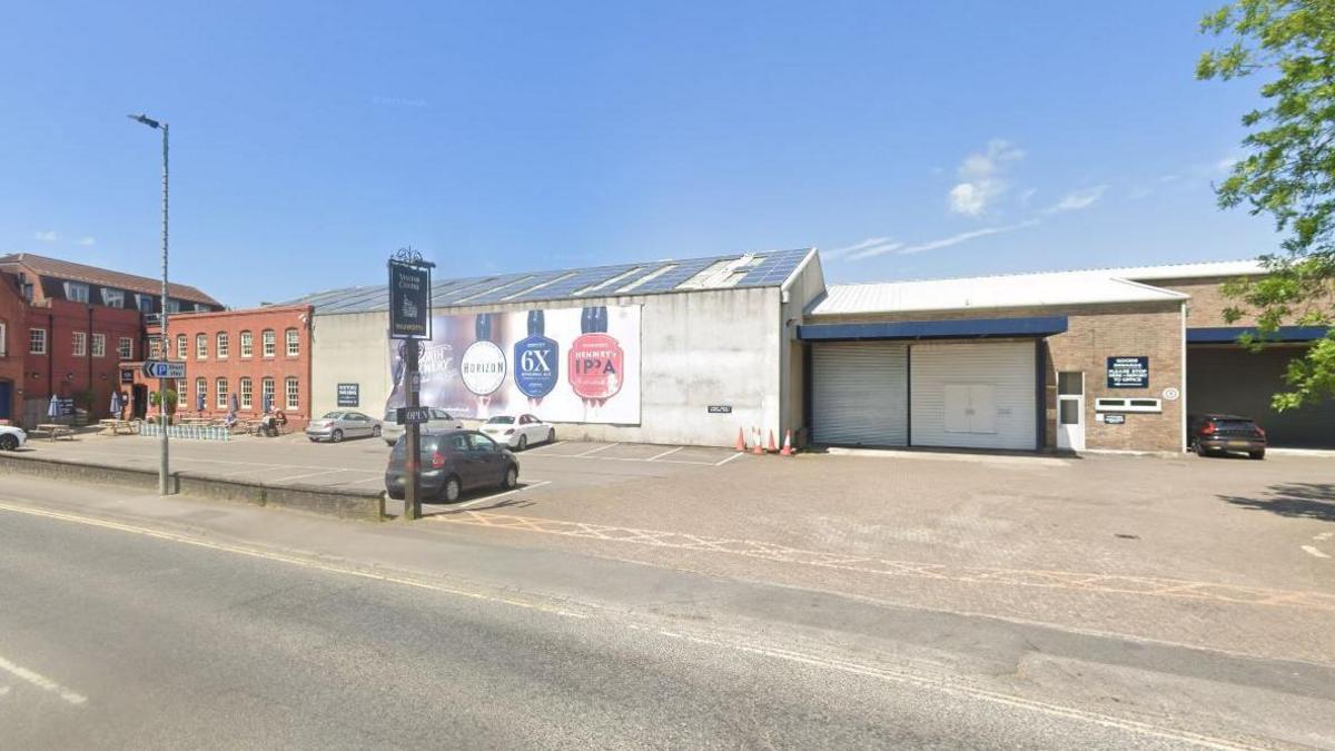 The site from the road as it is now, showing an industrial building that is modern and looks a bit like an industrial estate.