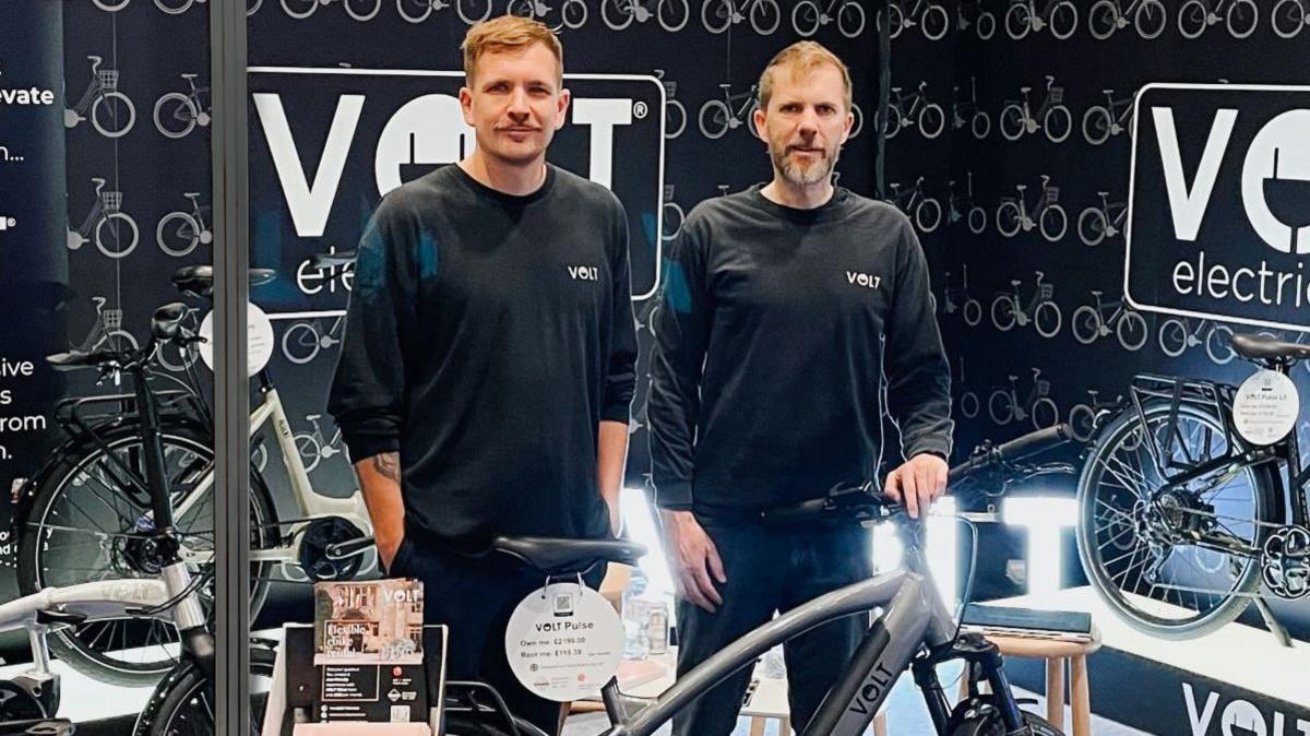 Lyle and James Metcalfe stand with e-bikes