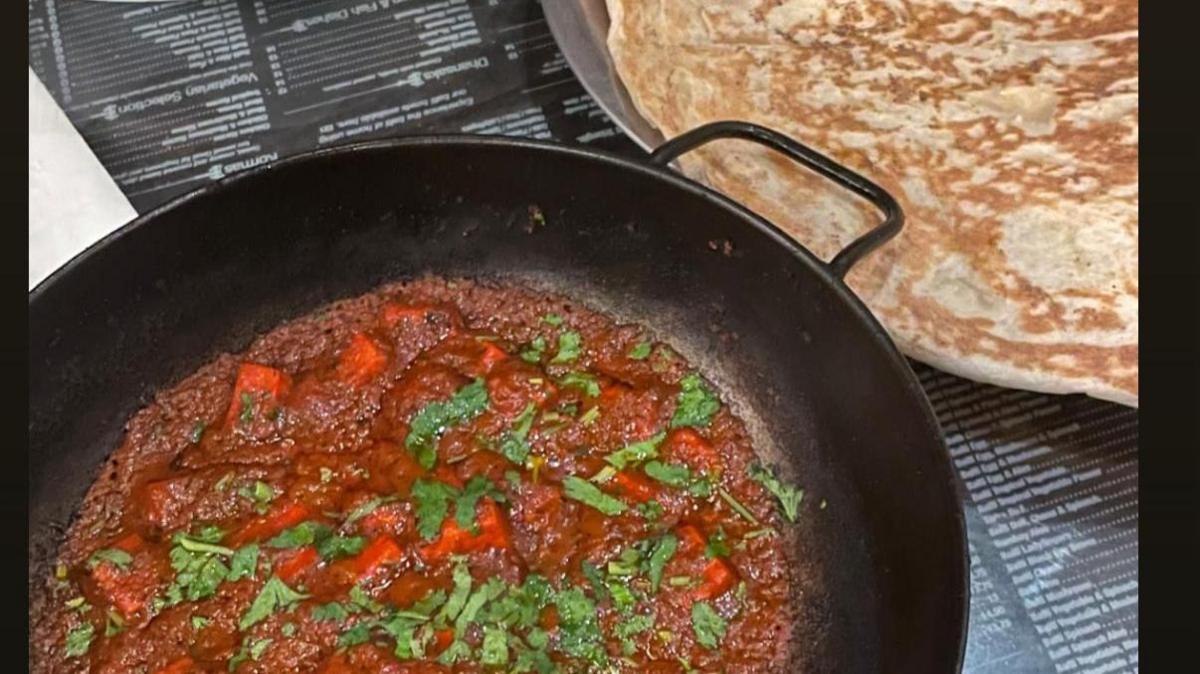 a balti next to a naan on some black menus with white writing