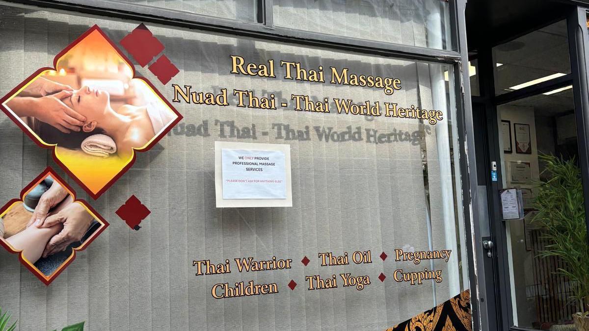 A close of the shop window and a sign that reads: "We only provide professional massage services. Please do not ask for anything else." 