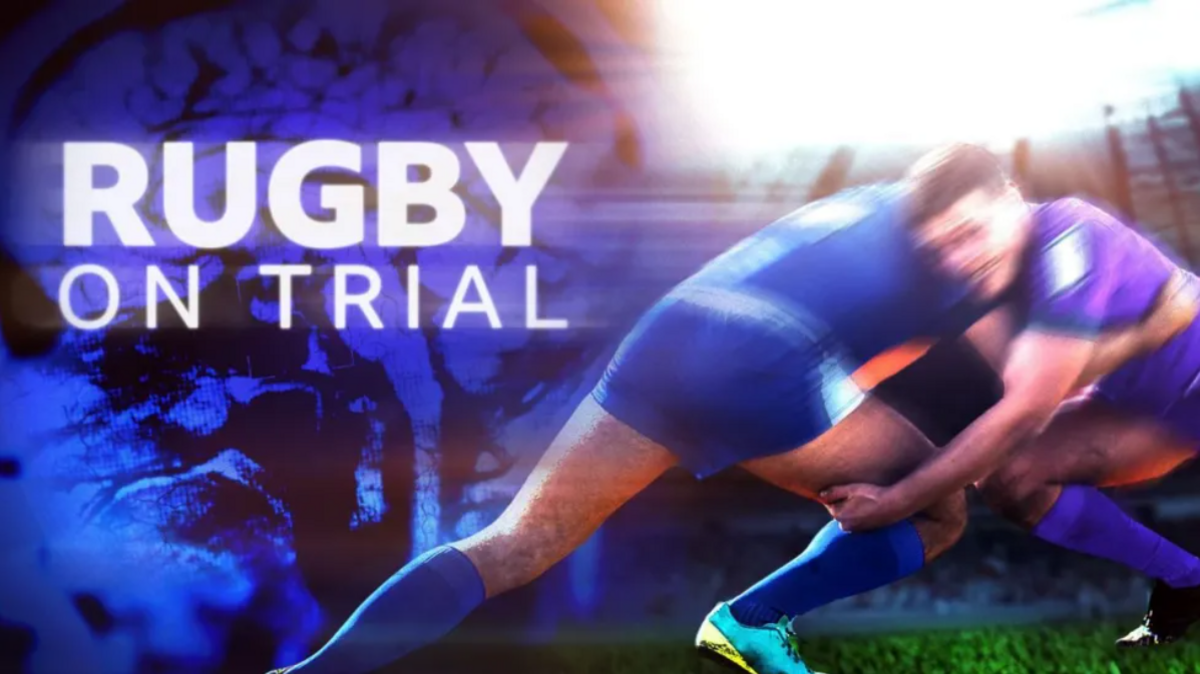 Two rugby players in blue kit tackling each other on a poster with the words " RUGBY ON TRIAL" in bold white letters against the backdrop of a brain scan picture