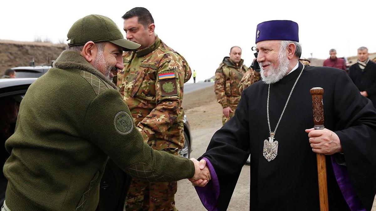 Armenia's prime minister shakes hands with the head of Church.