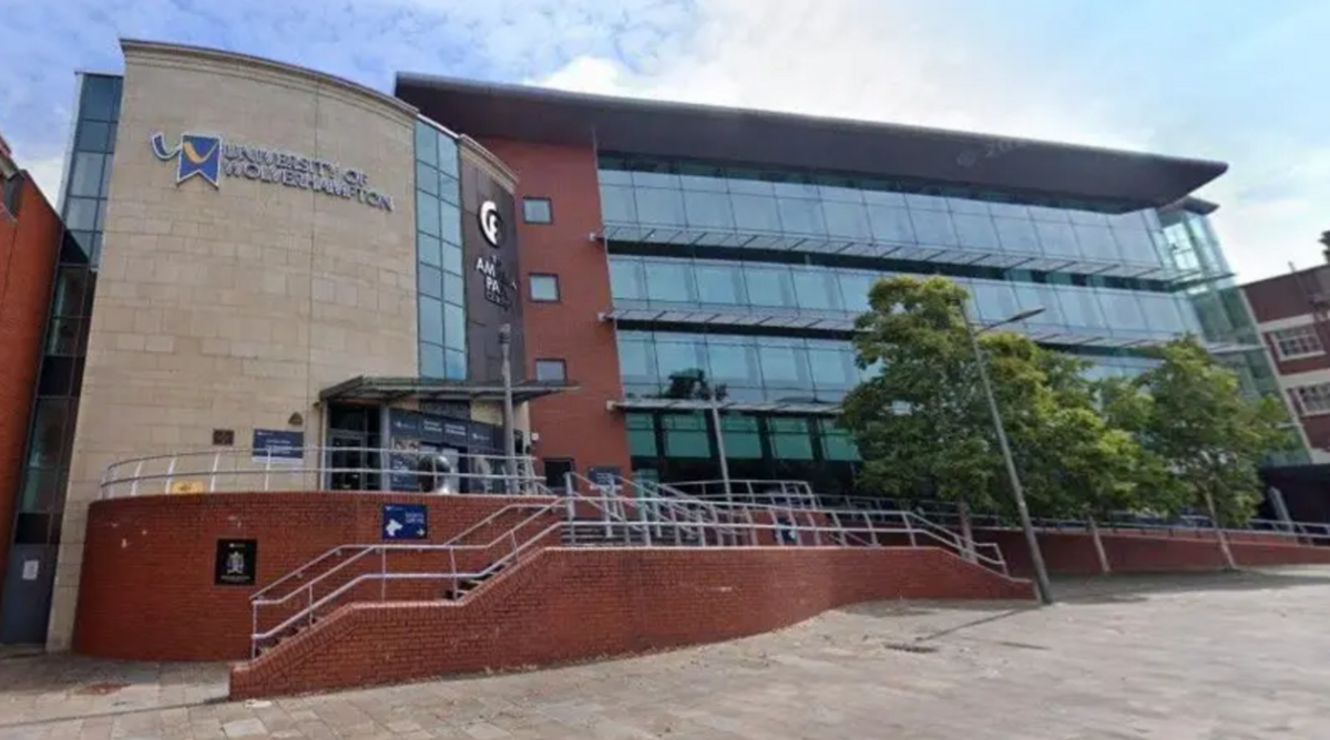 The front of a large, three storey, glass-fronted building with a handful of trees outside and a sign which reads University of Wolverhampton