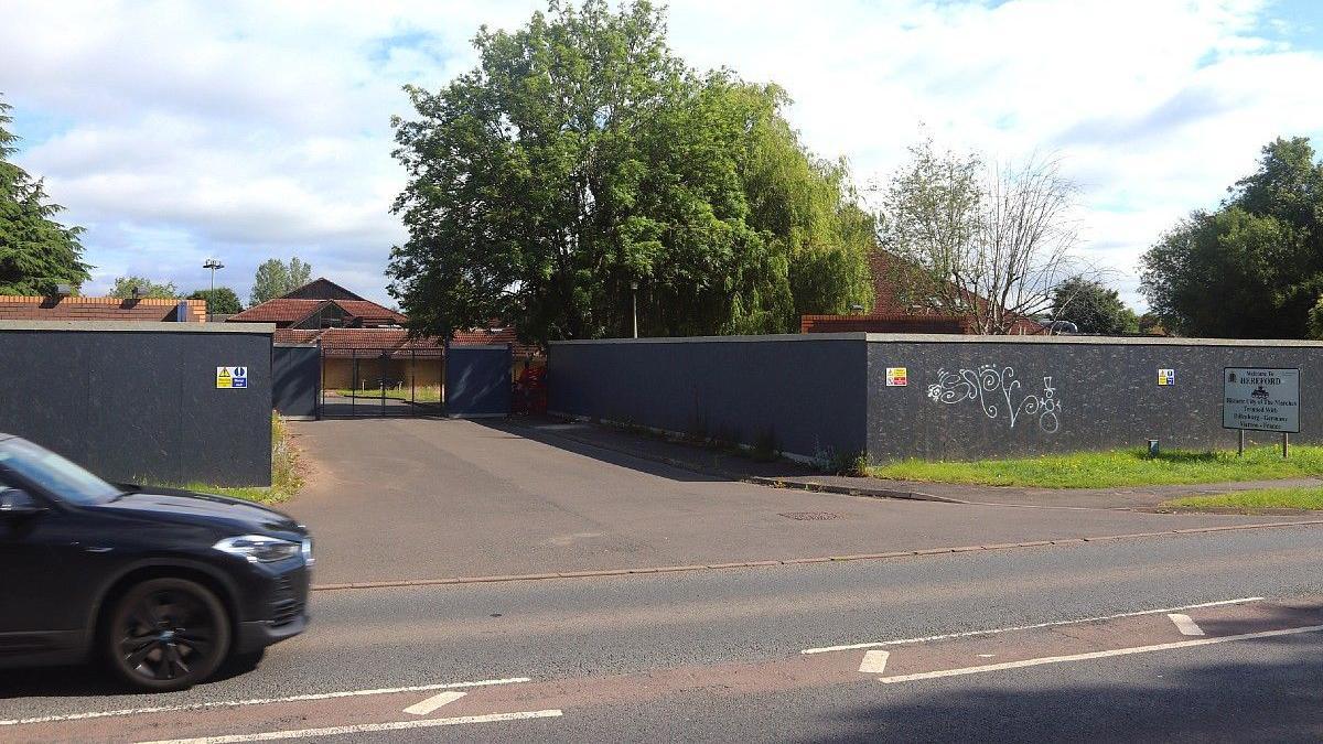 General view of the vacant Three Counties Hotel site showing boards around the perimeter