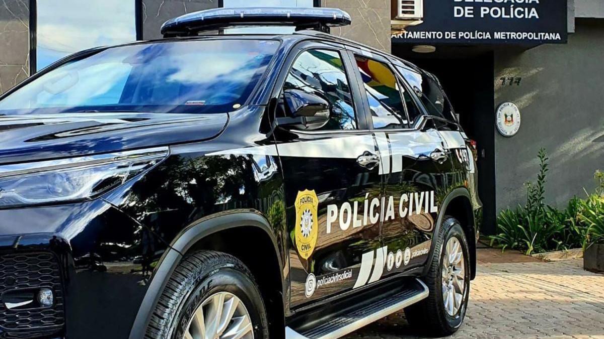 A police car is parked in front of a police station in Rio Grande do Sul