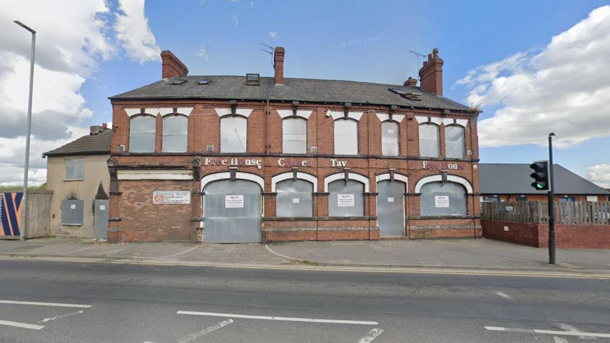 A Google streetview image of boarded-up, two-storey former pub building. 