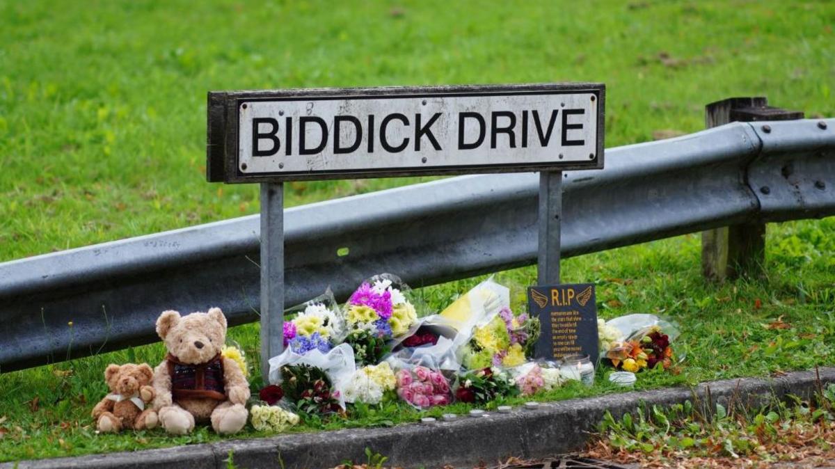 Biddick Drive sign with tributes underneath