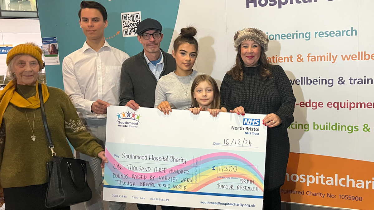 Harriet Anabell and her family stood behind a cheque for the Southmead Hospital Charity. 