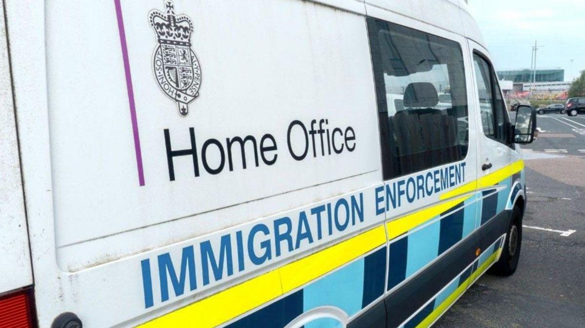 A parked van on the generic photo has the words "Home Office immigration enforcement" down the side. The vehicle is mainly white but also yellow and blue from front to back on the image nearer to the wheels.