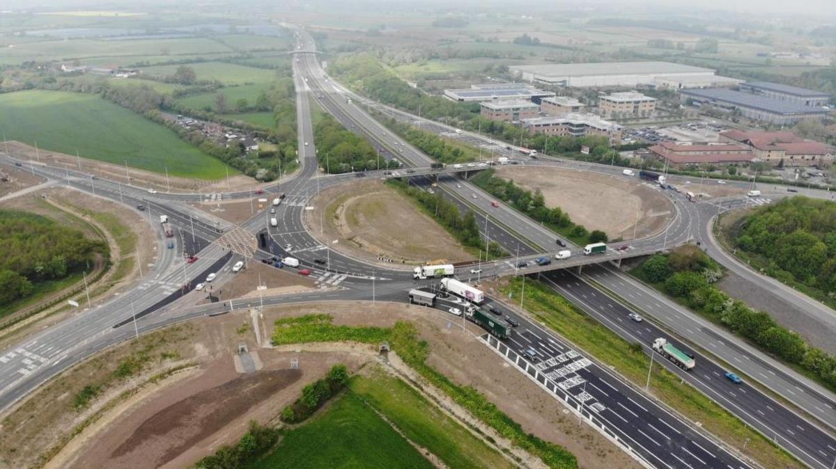 The M4 with multiple lanes of traffic and buildings and fields either side