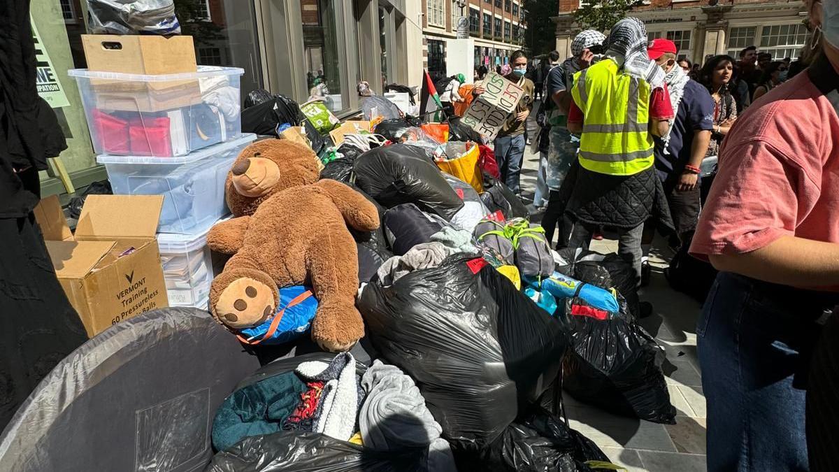 Bin bags and belongings of encampment protestors outside building