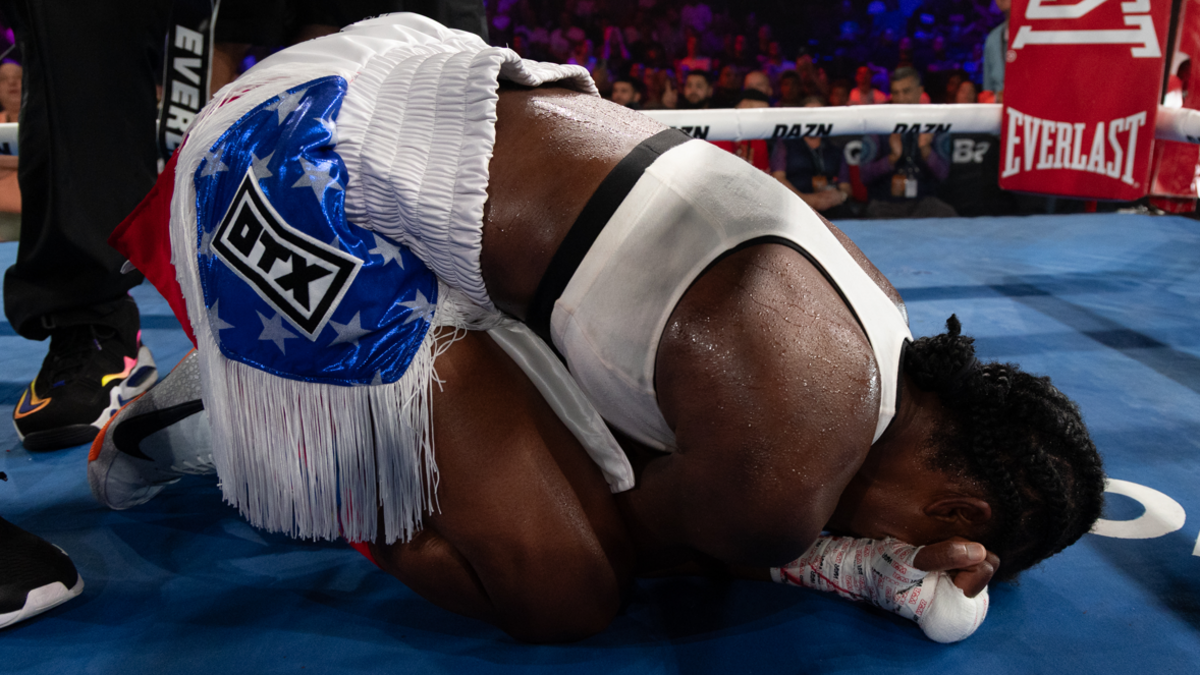 Tiara Brown on her knees in tears after winning a fight