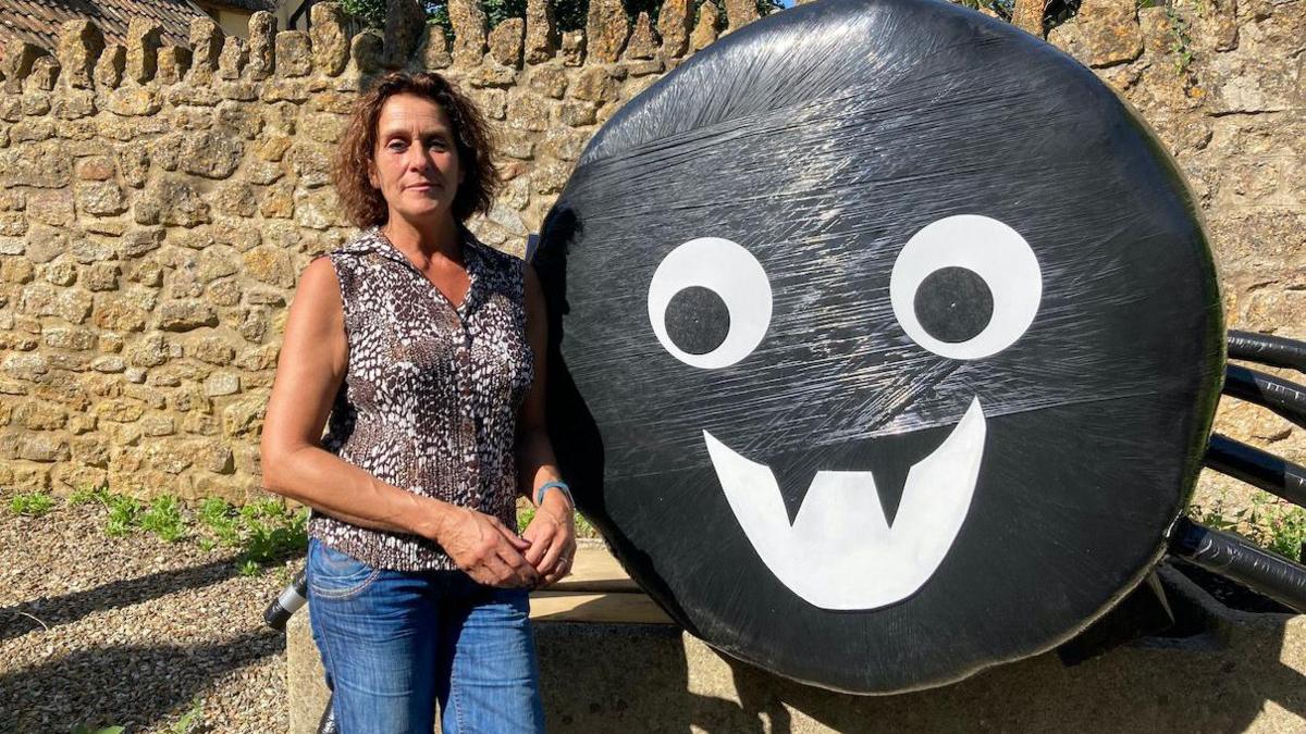 A woman standing next to a giant toy spider