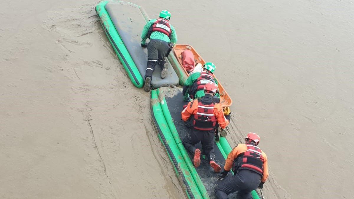 Fire fighters on boats on muddy water