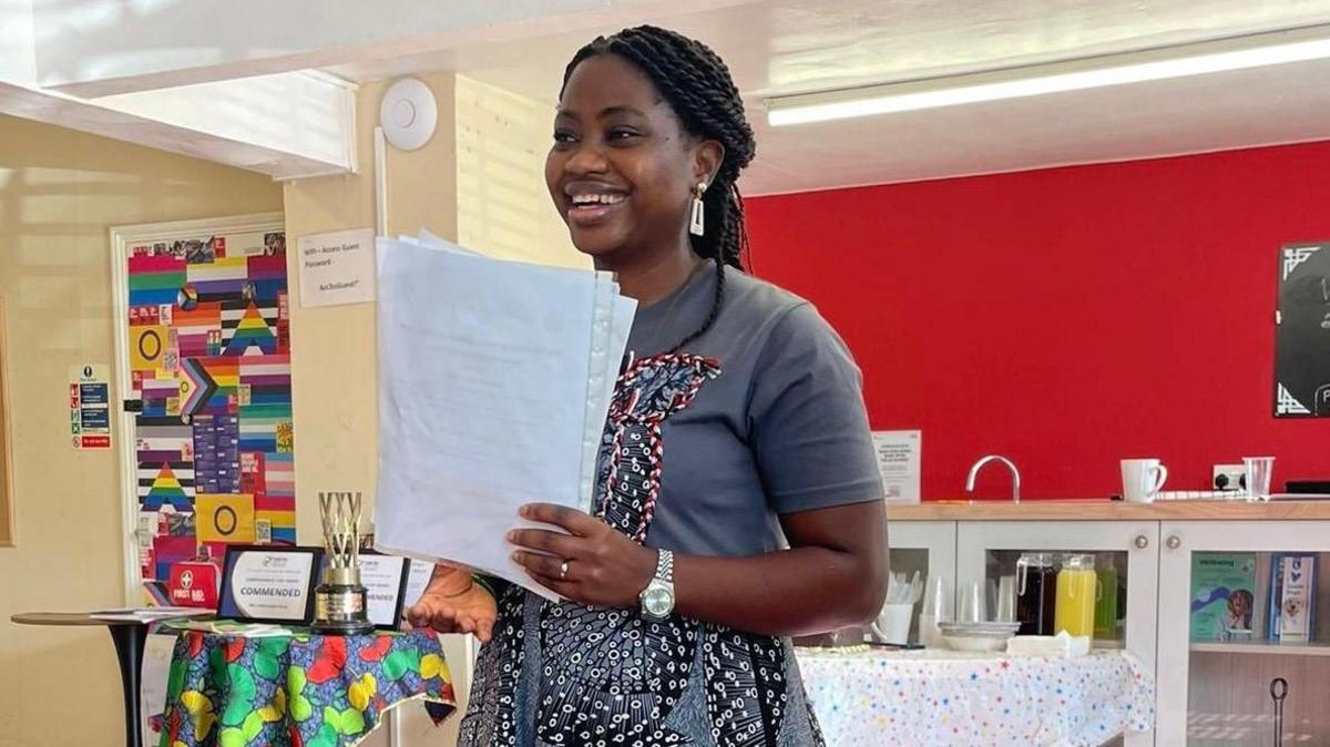 Funmi Akinriboya at Linden House in Bury St Edmunds, smiling with a table of drinks and food behind her.