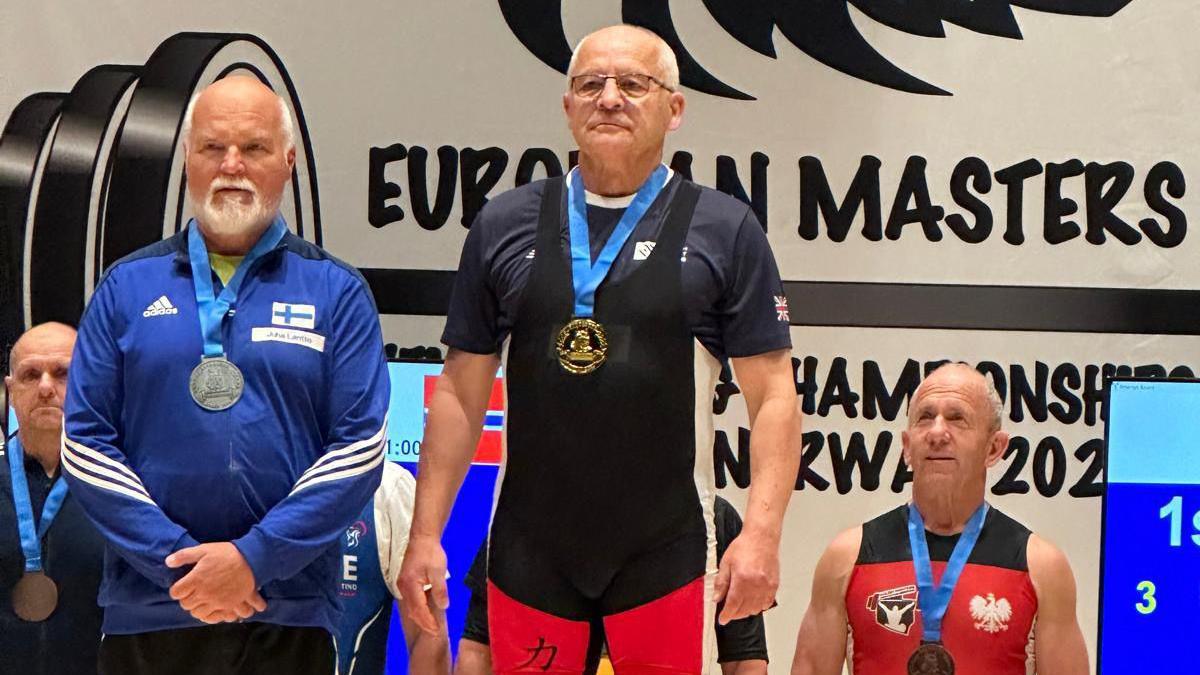 Bernard Trybull on the top podium wearing his medal, next to other winners