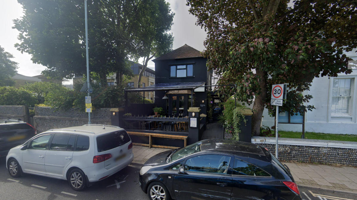 A black pub on a residential street.