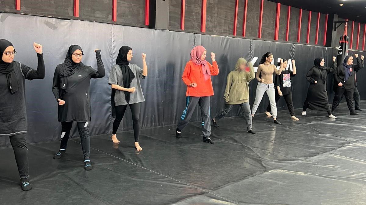 Women in sportswear in a row adopting a martial arts pose