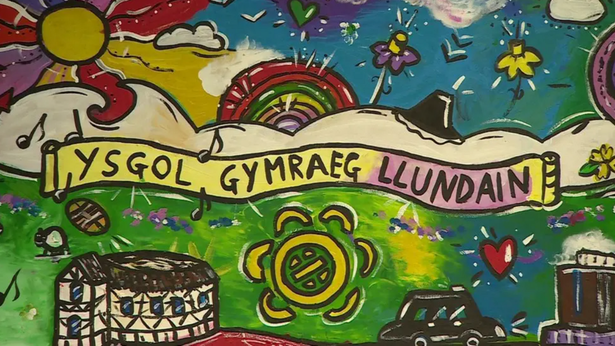 Paentiad yn nodi'r geiriau 'Ysgol Gymraeg Llundain'. Hefyd wedi paentio mae logo'r ysgol, theatr y Globe, enfys, daffodil, tacsi du, cerddoriaeth a phel rygbi.