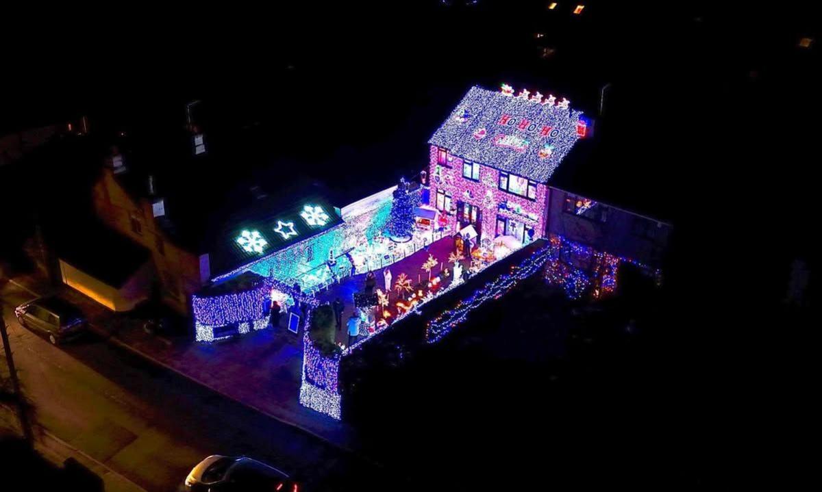 An aerial photo of a house and garden covered in Christmas lights.