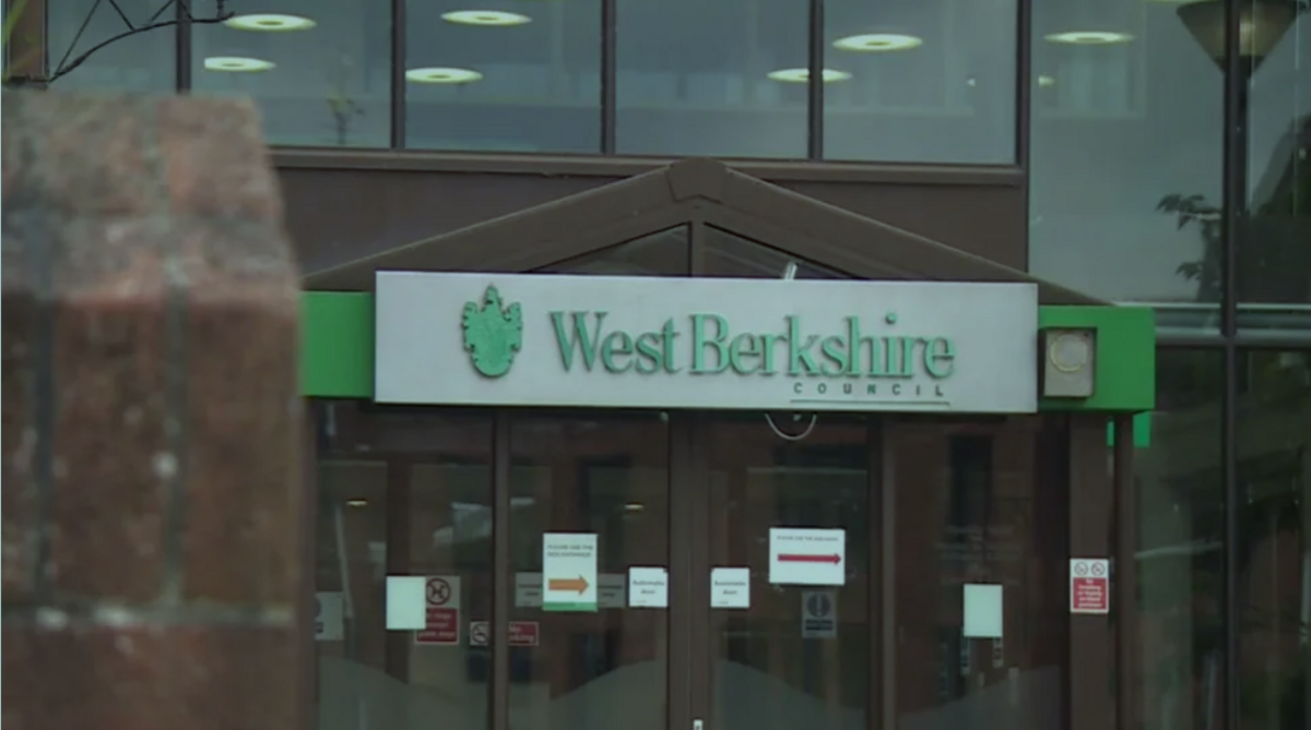 West Berkshire Council building , red brick building with green sign outside on top of glass doors.