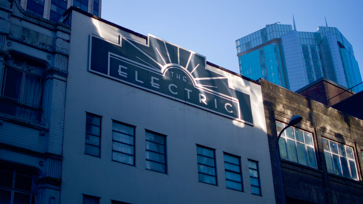 A white multi-storey building with a sign in Art Deco style 