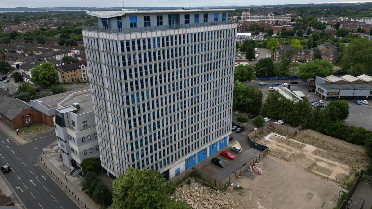 A drone image of The Heights, a large block of flats with three cars outside